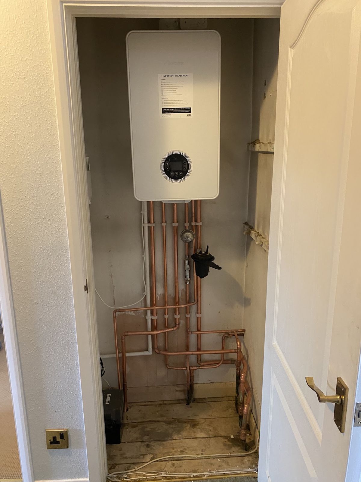 Boiler in a cupboard with new copper pipework running to the floor