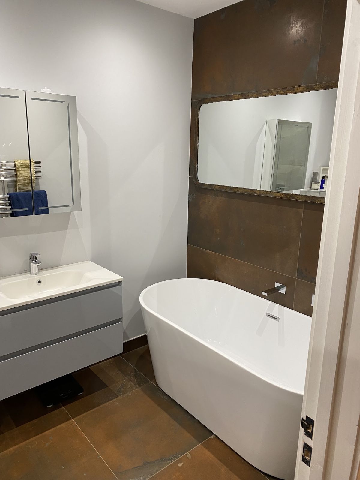 A refitted bathroom with a freestanding bath and wall-hung vanity
