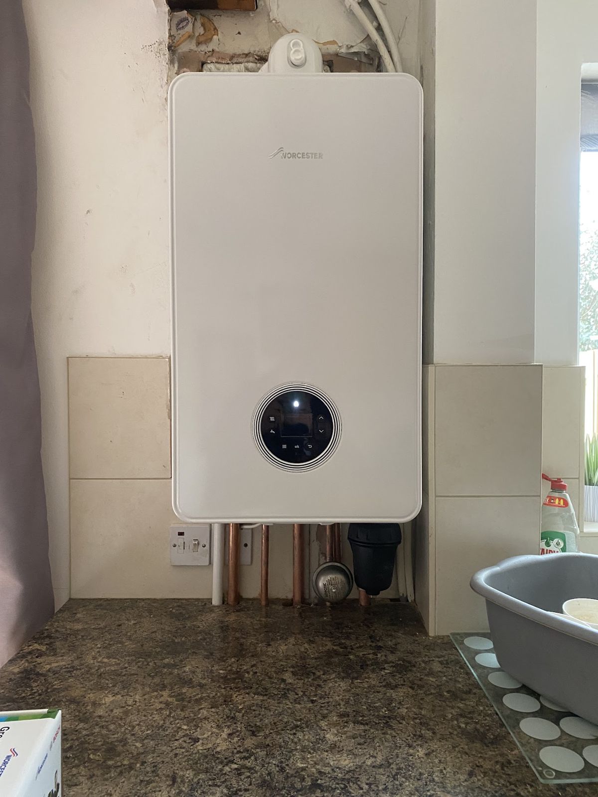 A new Worcester Bosch boiler fitted above a kitchen worktop with neat copper pipework